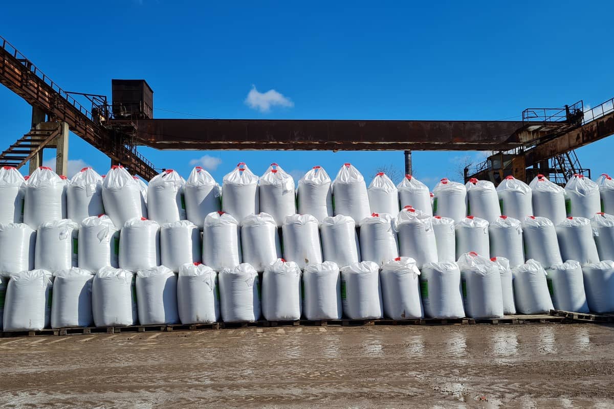 Products packaged in many white big bags in an outdoor warehouse