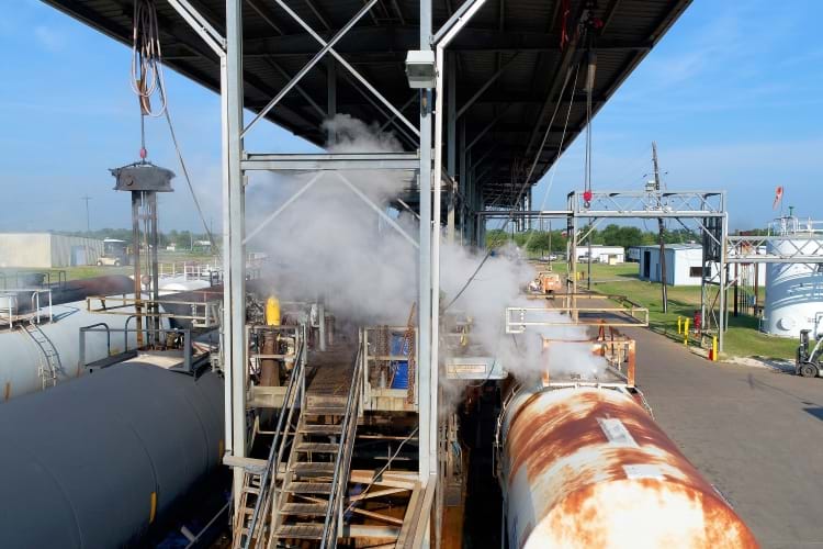 Tank-style railcars undergoing a steaming treatment as an initial part of the railcar cleaning process