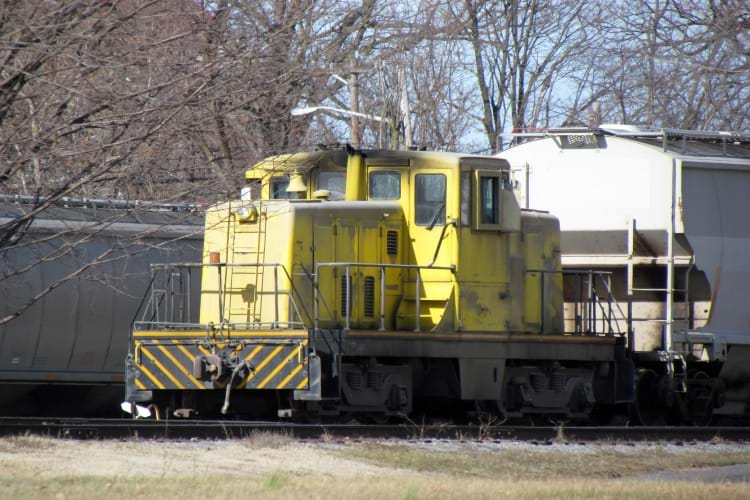 A rail yard locomotive (switcher) pulls grain railcars around at a feed mill