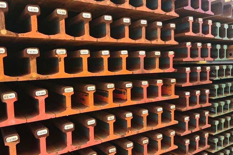 Neatly stacked new railway tracks in a stock yard