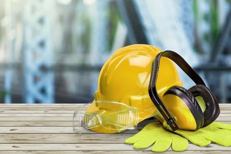Yellow safety helmet with earphones, goggles, and gloves