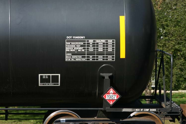 Tank car qualification stencil with black background and white grid & lettering
