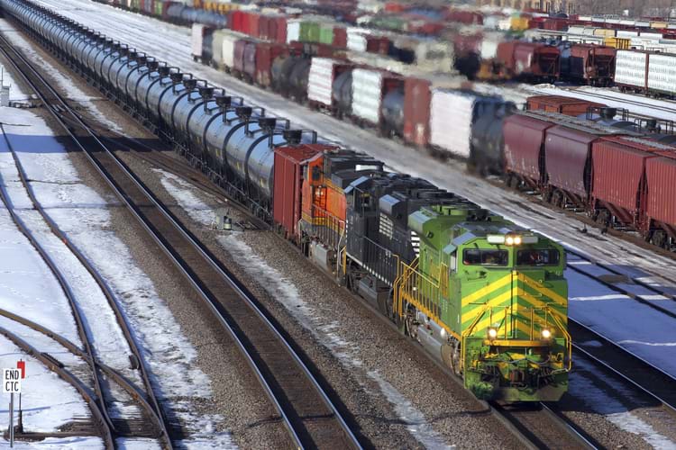 A railcar storage yard covered with snow with different types of freight cars