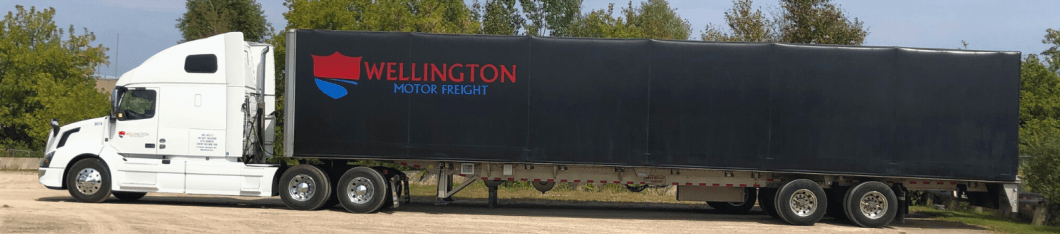 A Wellington Motor Freight transport truck pulling a roll tite trailer.